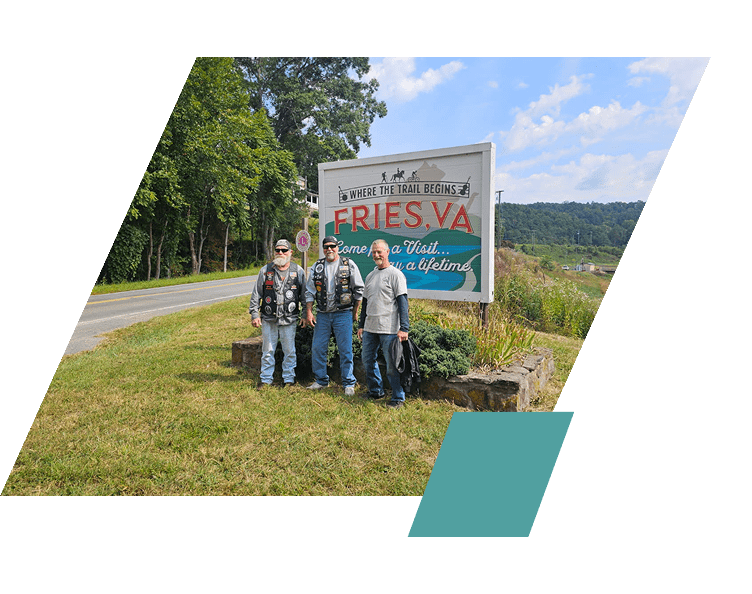 Family posing near a large Fries VA sign outdoors.